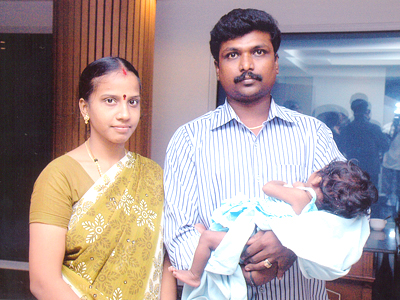 Proud parents holding their 3 month old baby following successful open heart surgery